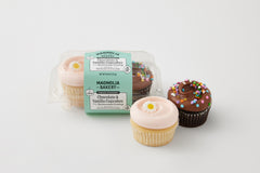 vanilla cupcake with pink buttercream topped with a daisy decon and chocolate cupcake with chocolate buttercream topped with confetti sprinkles in a clear plastic package and the same two cupcakes outside of the packaging