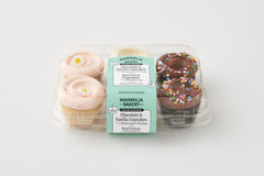 2 chocolate cupcake with chocolate buttercream and confetti sprinkles, 2 red velvet cupcakes, 2 vanilla cupcakes with pink buttercream icing with a flower decon in a plastic 6 pack container