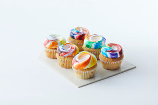 6 cupcakes topped with rainbow meringue